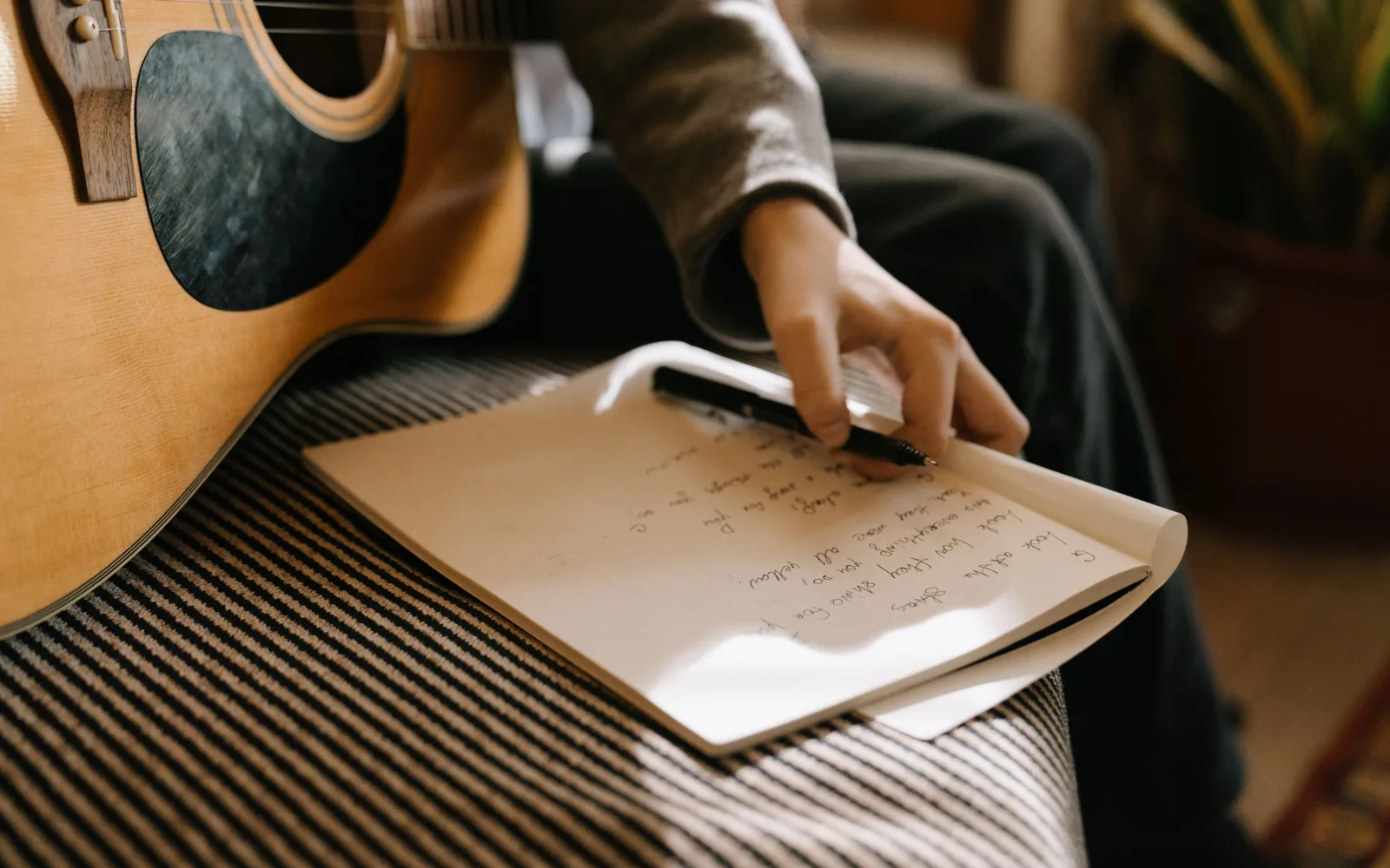 Un musicien note la liste de ses morceaux dans un carnet de studio